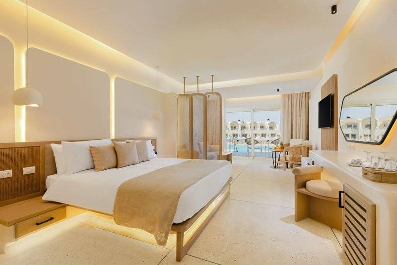 Hotelzimmer im Sunrise Anjum Resort mit Blick auf den Pool und modernem Interieur.