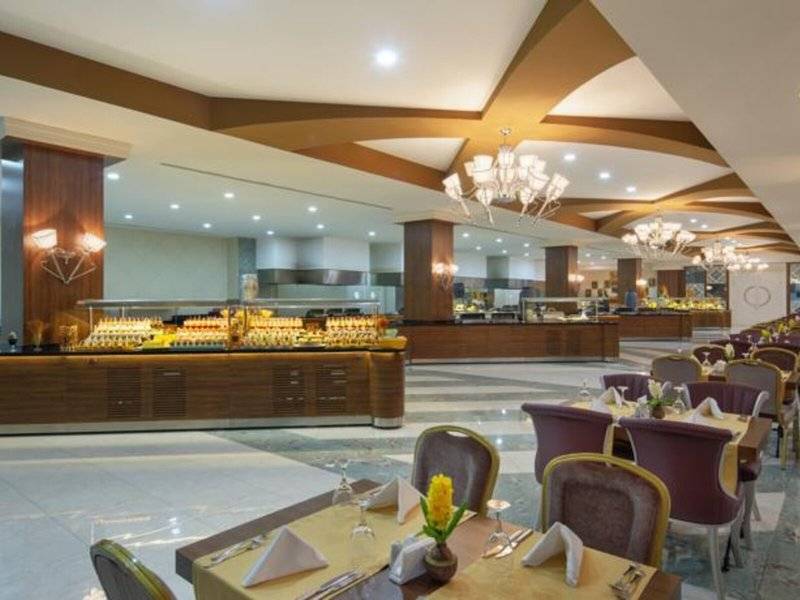 Innenansicht des Restaurants im Alan Xafira Deluxe Resort & Spa mit vielen Tischen und Stühlen.