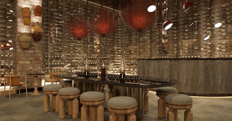 Innenbereich des Ethno Belek Hotels mit Bar, Holzstühlen, Weinflaschen und roten Lampen