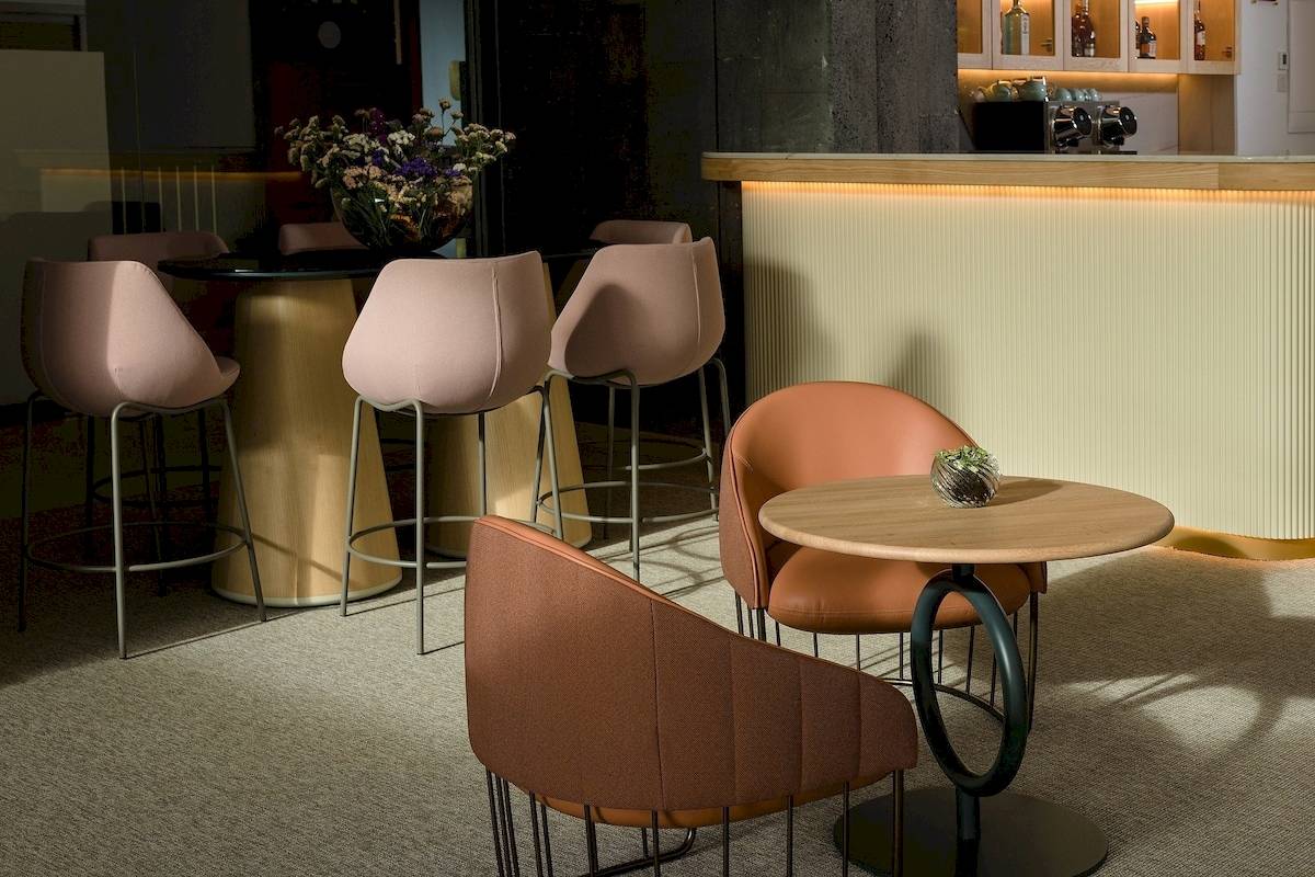 Innenansicht der Bar im Plus Fariones Suite Hotel mit Barhockern und Tischen.