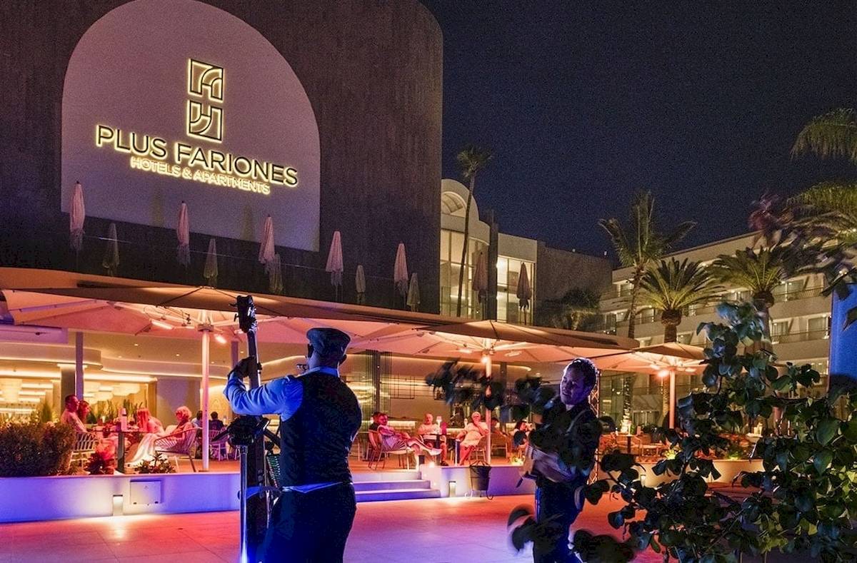 Außenbereich des Plus Fariones Suite Hotels bei Nacht mit Beleuchtung und Gästen.