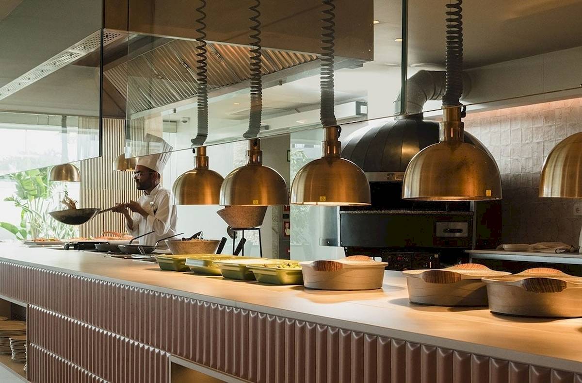 Koch in der Küche des Plus Fariones Suite Hotels mit Töpfen und Pfannen auf dem Tisch