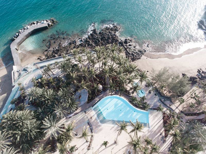 Luftaufnahme des Fariones Hotels mit Pool und Palmen, Blick vom oberen Balkon.