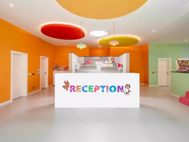 Innenansicht der Rezeption des Kirman Leodikya Resorts mit bunten Wänden und einer Willkommens-Ausstellung.