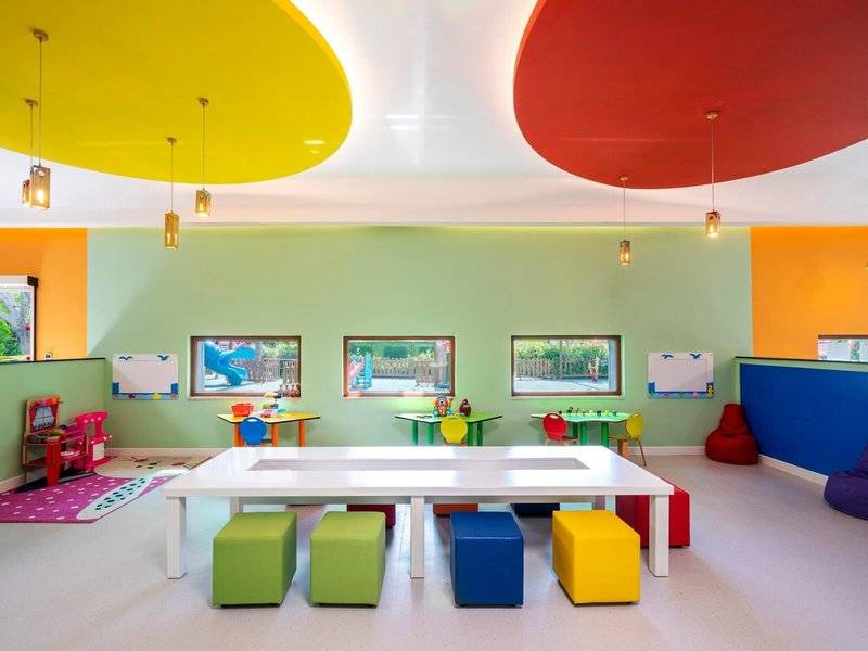 Bunte Kinderspielecke im Hotel mit farbenfrohen Möbeln und bunten Wänden.