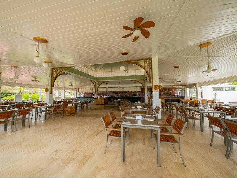 Innenbereich des Ducale Lara Hotels mit Holzböden und weißen Decken mit Ventilatoren.