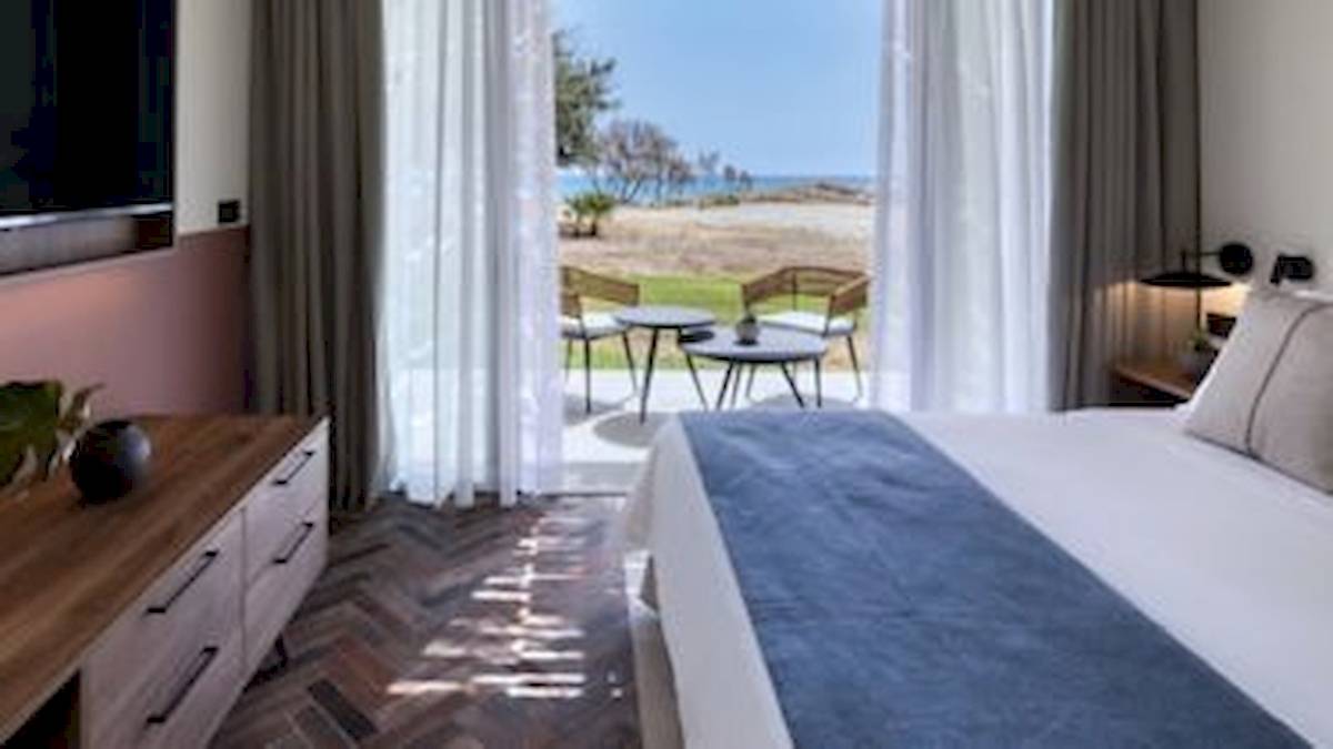Innenansicht eines Hotelzimmers im Domes Aulus Zante mit Blick auf den Strand und das Meer.