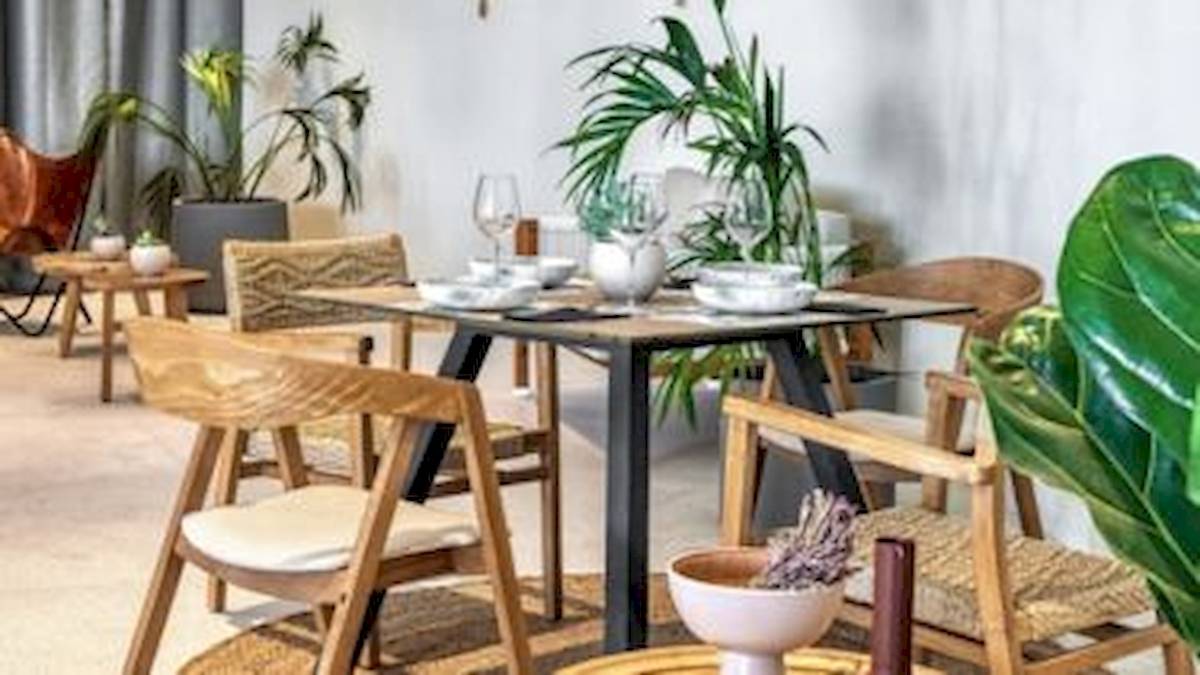 Restaurantbereich des Domes Aulus Zante Hotels mit gedecktem Tisch und Holzmöbeln.