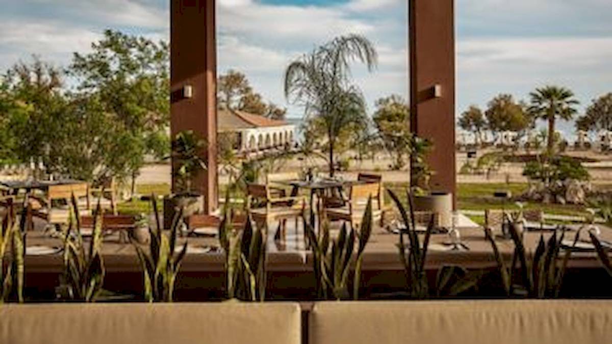 Außenbereich des Domes Aulus Zante Hotels mit Tischen, Stühlen und Pflanzen