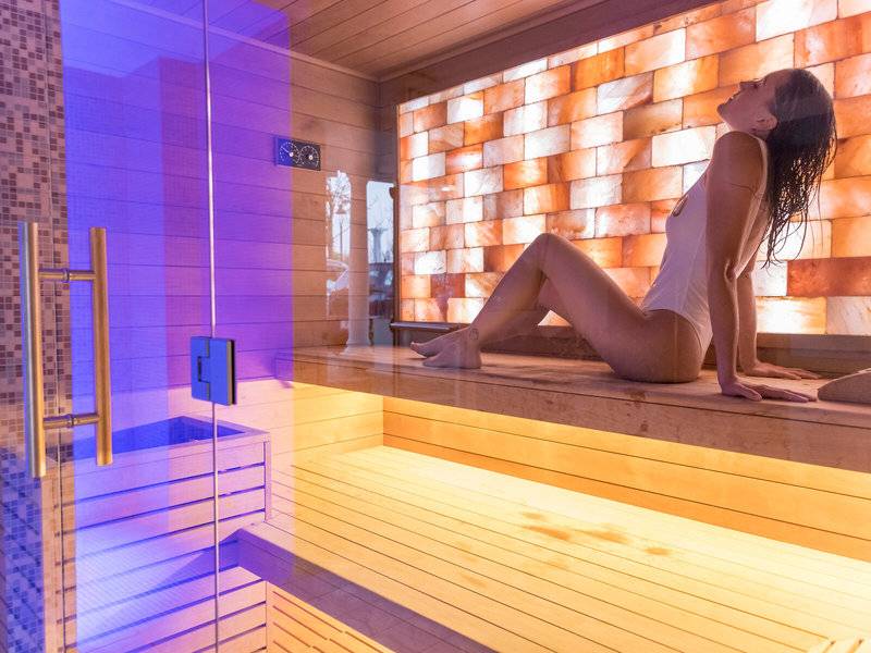 Frau sitzt in der Sauna des Baia Imperiale Hotels und blickt nach oben.