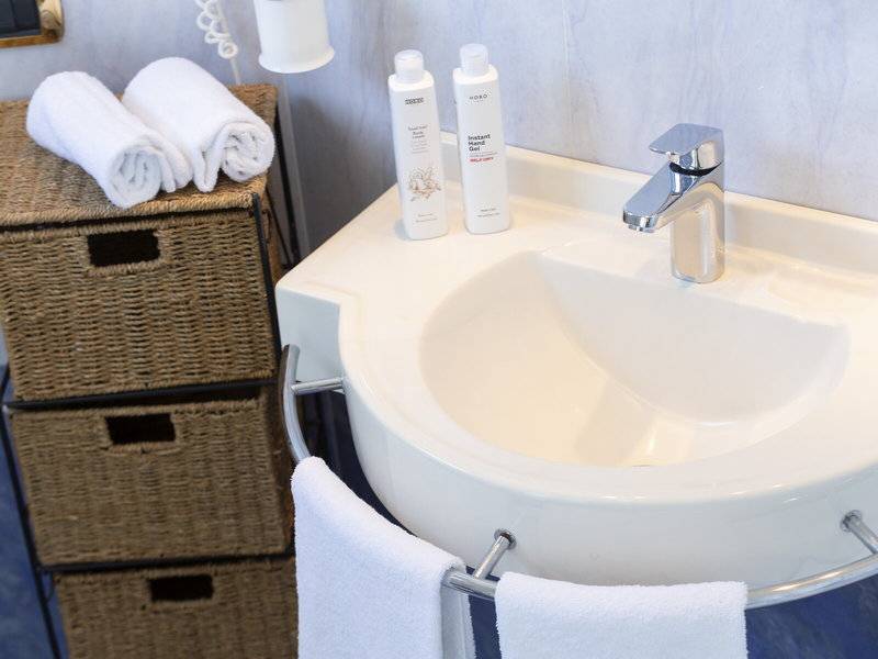 Badezimmer im Baia Imperiale Hotel mit Waschbecken, Handtüchern und Körperpflegeprodukten.