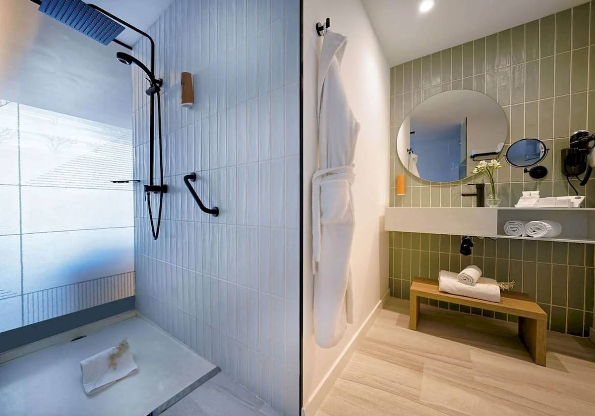 Badezimmer im H10 Costa Mogan Hotel mit Dusche, Handtuchhalter und grünen Fliesen.