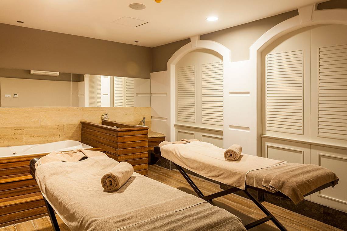 Massageraum im Belek Beach Resort Hotel mit zwei Massagetischen und einem Badewanne