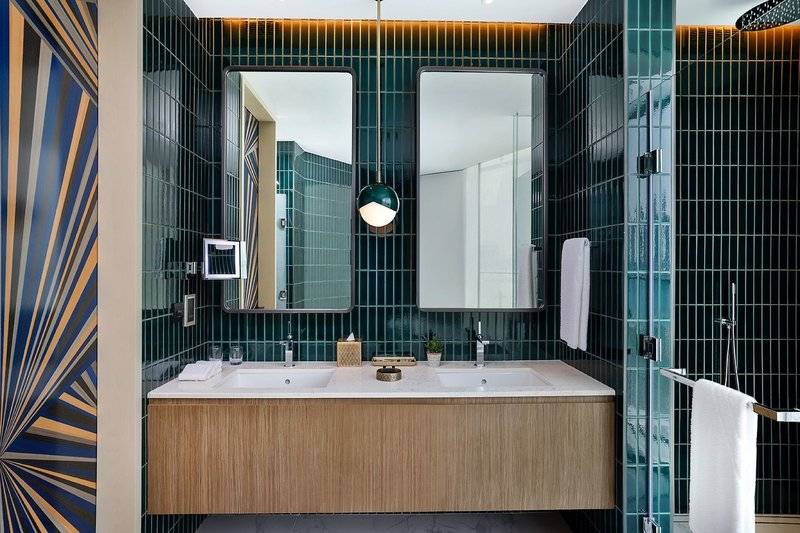 Badezimmer im W Dubai - Mina Seyahi Hotel mit grünen Fliesen und blauen Streifenmuster