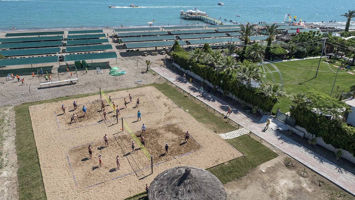 Luftaufnahme eines Volleyballspiels am Strand des Belek Beach Resort Hotels mit Blick auf das Meer und die Bucht.