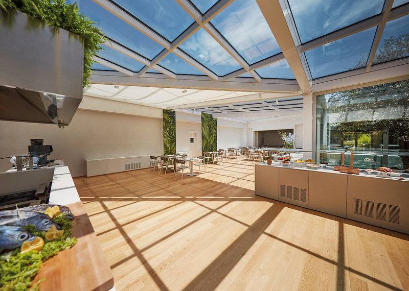 Innenbereich des VOI Marsa Siclà Essentia Hotels mit Glasdach und Holzboden.