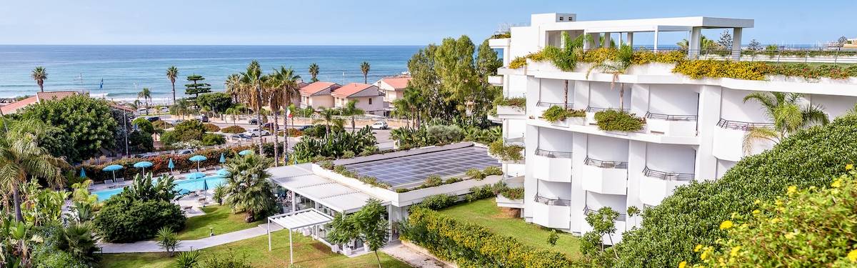 Außenansicht des Acacia Palace Hotels mit Blick auf den Ozean und einen Swimmingpool