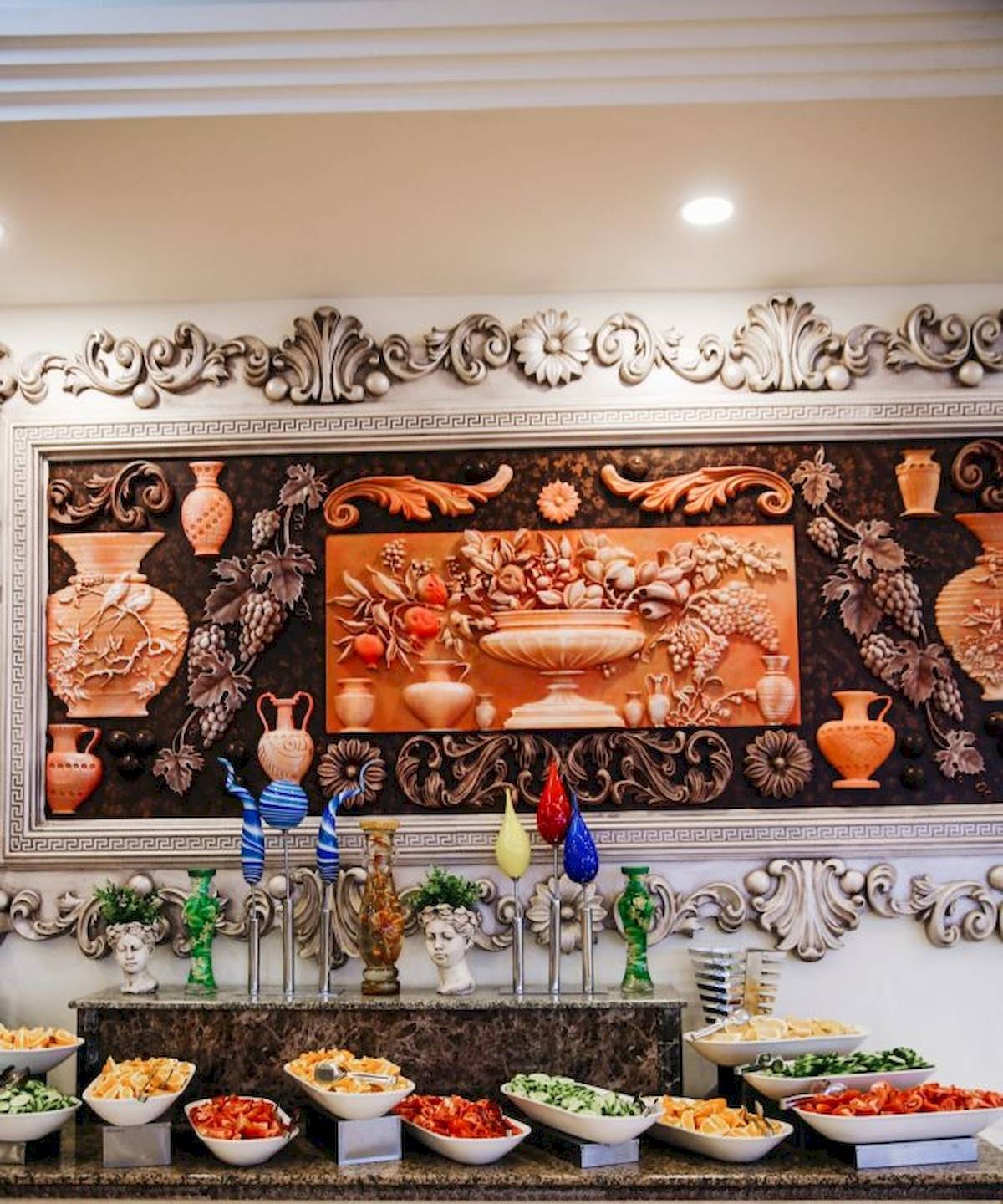 Buffet-Tisch im Cesars Side Hotel mit verschiedenen Gemüsesalaten und dekorativen Vasen.