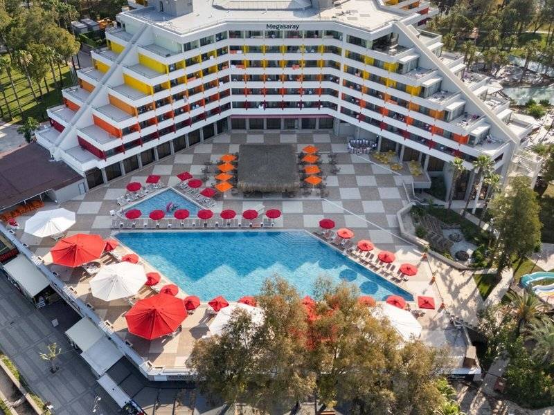 Luftaufnahme des Megasaray Resort Side mit großem Pool und vielen roten Sonnenschirmen.