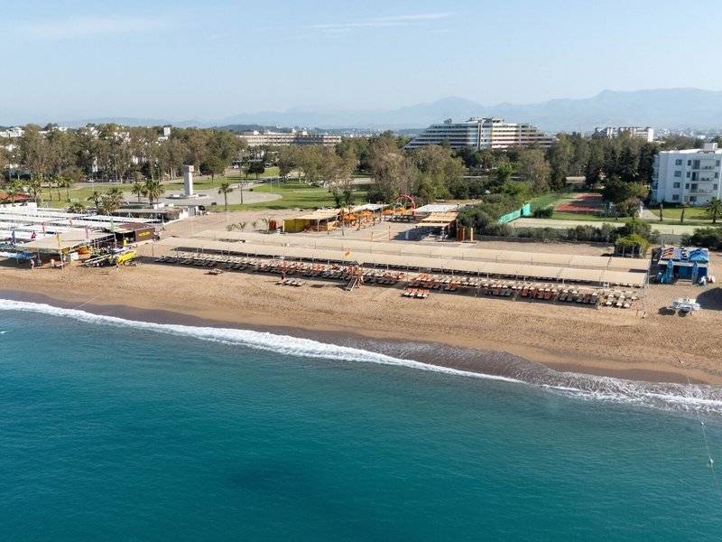 Luftaufnahme des Megasaray Resort Strands in Side mit Liegestühlen und Gebäuden