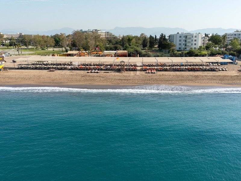 Luftaufnahme des Megasaray Resort Side Strand mit Sonnenliegen und blauem Wasser