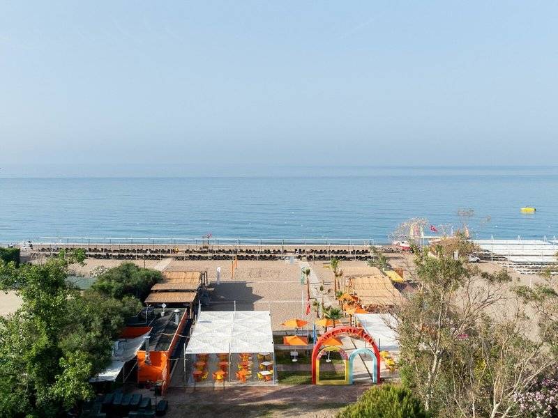Ausblick auf den Strand des Megasaray Resort in Side mit Pavillons und Sonnenschirmen.