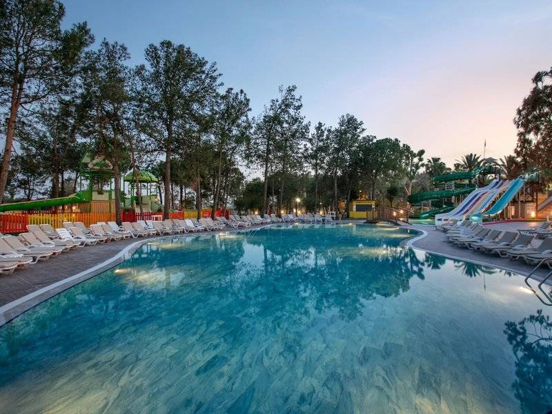 Außenpool des Megasaray Resort Side bei Dämmerung mit Wasserrutschen und Liegestühlen