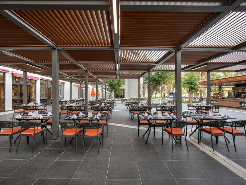 Außenrestaurant des Megasaray Resort Side mit Tischen, Stühlen und Schirmen.