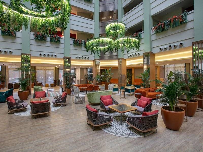 Lobby des Megasaray Resort Side mit Pflanzen, Sofas und Tischen.