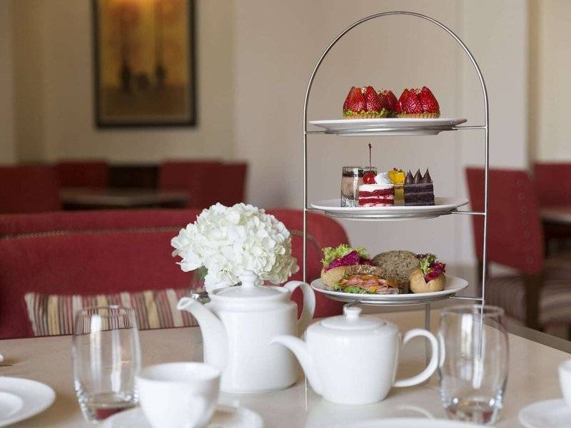 Das Al Najada Doha Hotel by Tivoli serviert einen Nachmittagstee mit verschiedenen Kuchen und Sandwiches.