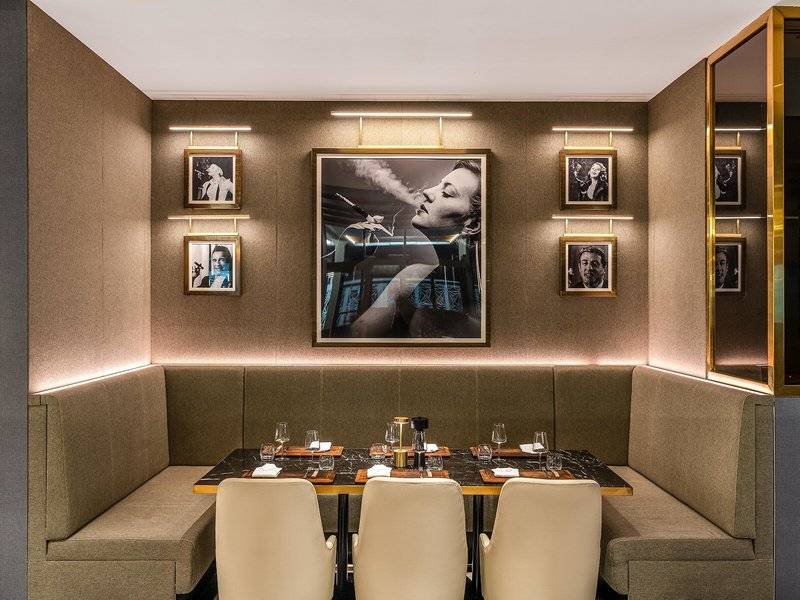 Innenraum des Rixos Gulf Hotel Doha mit einem großen Bild und vier kleineren Porträts an der Wand.
