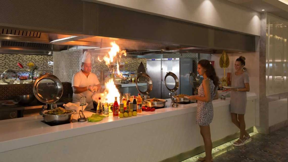 Chef brät Gerichte am offenen Feuer im Royal Taj Mahal Hotel.