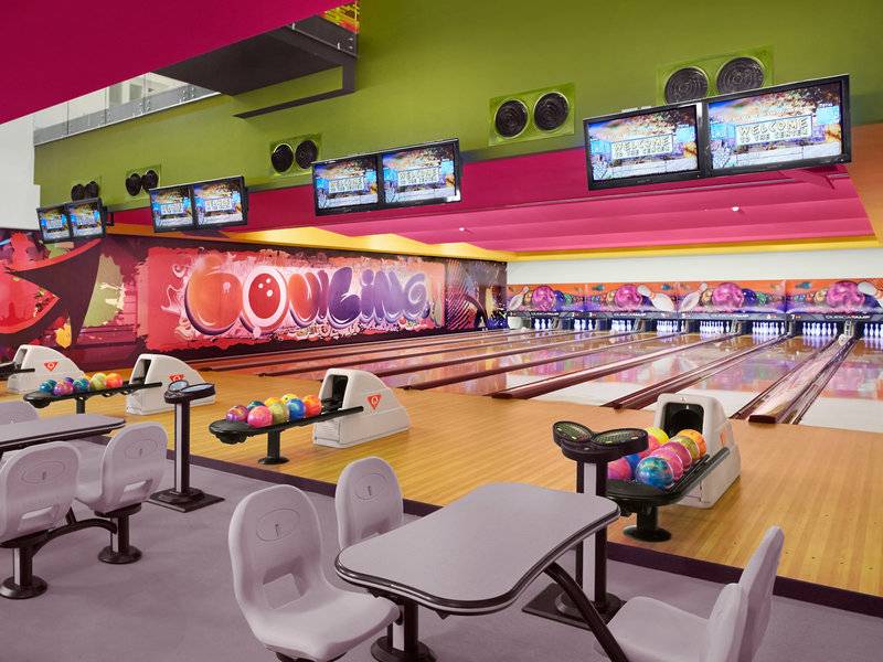 Bowlinghalle im Banana Island Resort Doha von Anantara mit bunten Bowlingbahnen und Bildschirmen
