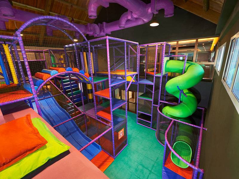 Kinderspielplatz im Banana Island Resort Doha mit bunten Spielgeräten und einer Rutsche.