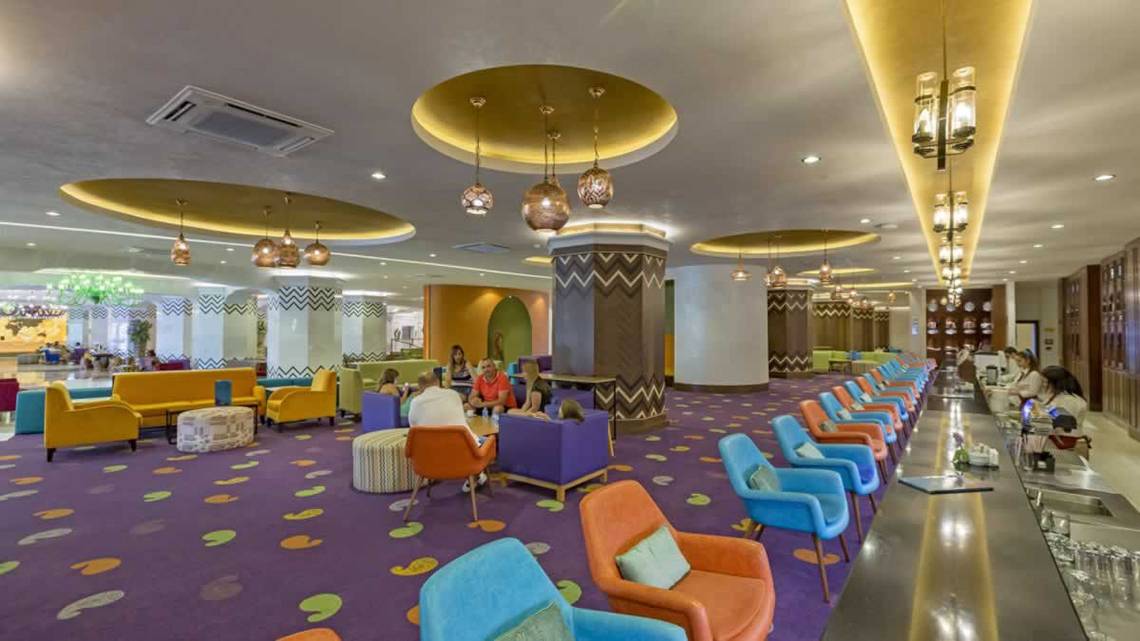 Lobby des Royal Taj Mahal Hotels mit bunten Stühlen und Tischen.