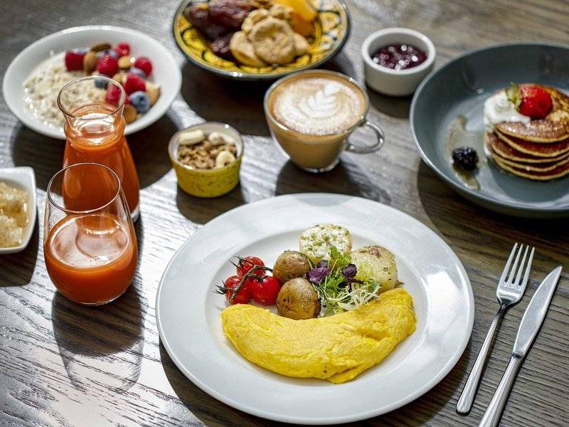 Frühstücksbuffet im Hyatt Regency Oryx Doha mit verschiedenen Gerichten und Getränken auf einem Holztisch.