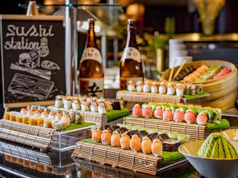 Sushi-Station im Hyatt Regency Oryx Doha mit verschiedenen Sushi-Platten und Getränken.