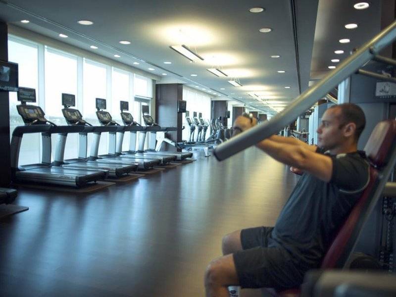 Fitnessstudio im Hyatt Regency Oryx Doha mit Läufern und Hantelbank