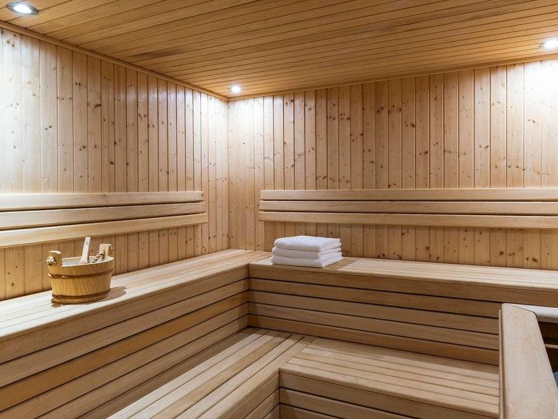 Innenraum einer Sauna im Hyatt Regency Oryx Doha mit Holzwänden und Bänken.