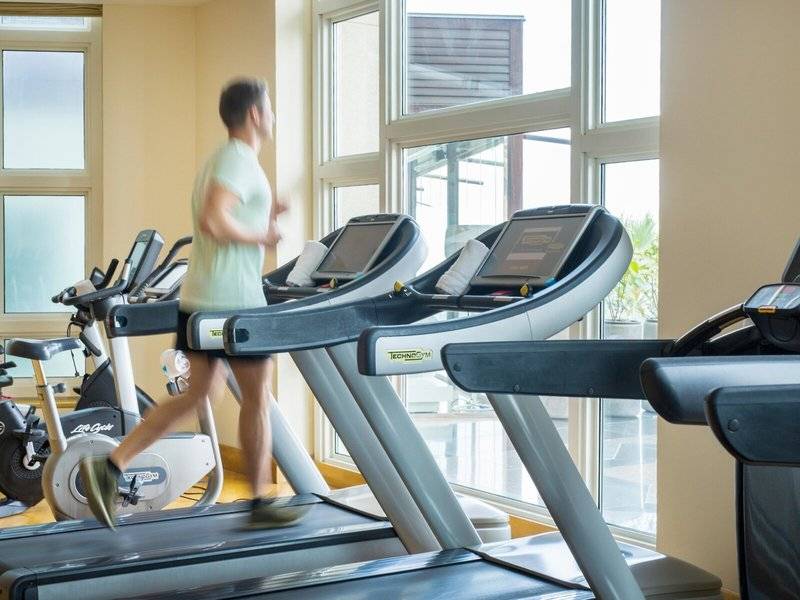 Person, die auf einem Laufband im Fitnesscenter des Four Seasons Hotel Doha läuft.