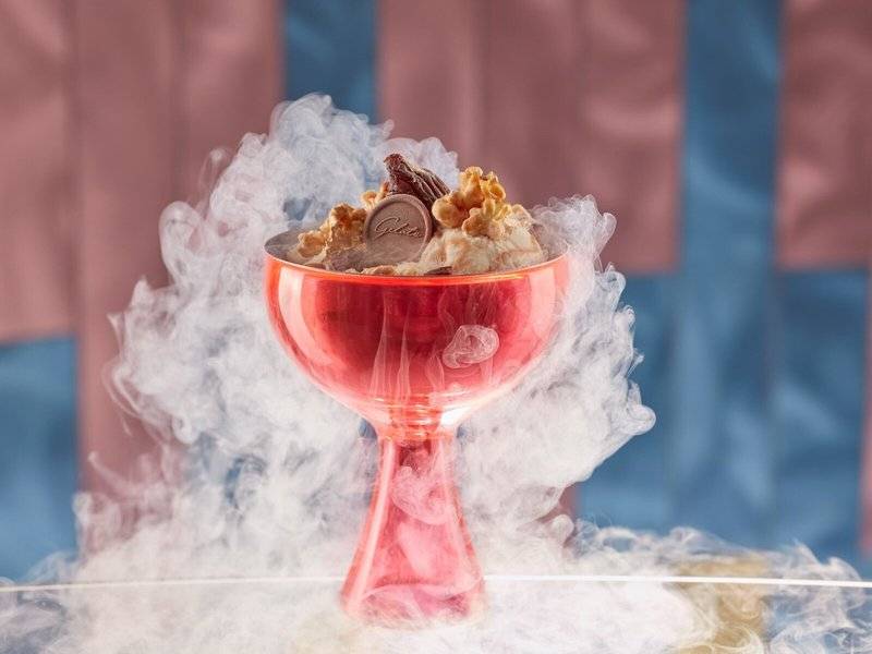 Eisbecher im Mandarin Oriental Doha mit weißem Rauch und einem Schokoriegel obenauf