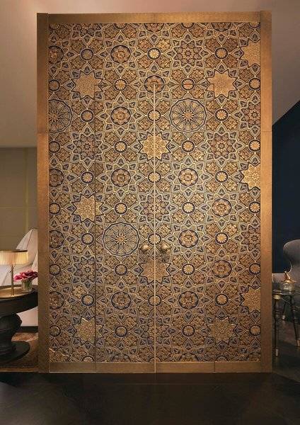 Dekorierte Tür im Raffles Doha Hotel mit goldenen und blauen geometrischen Mustern.