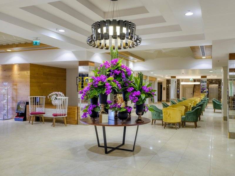 Lobby des Grand Park Lara Hotels mit Tisch, Blumen und Stühlen