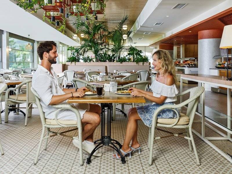 Ein Paar sitzt in einem Restaurant des Grand Park Lara Hotels an einem Tisch.