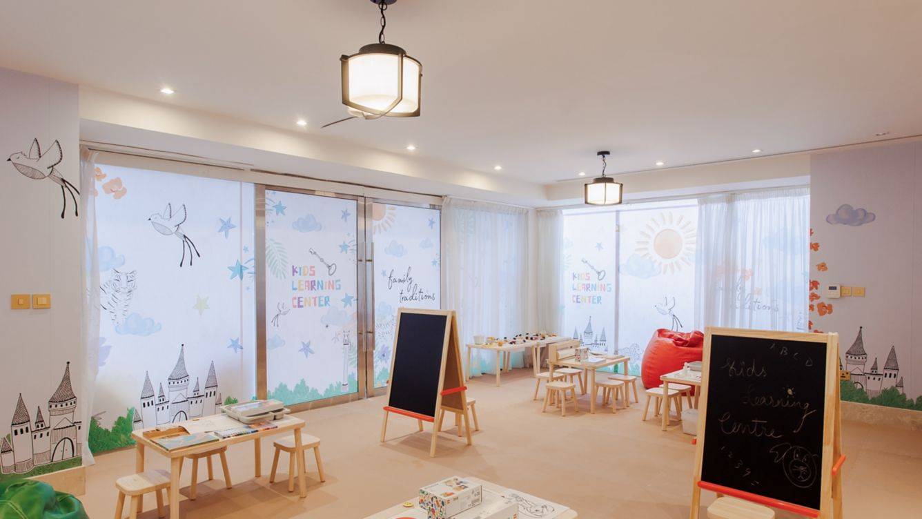 Das Kinder Lernzentrum im St. Regis Doha mit bunten Wänden, Tischen und Stühlen.
