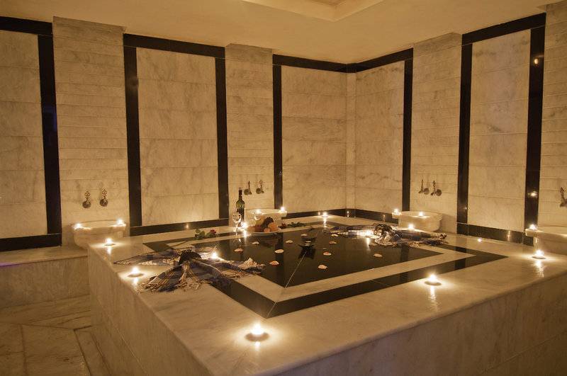 Ein elegantes Badezimmer im Yalihan Una Hotel, geschmückt mit Kerzen und Blumen.
