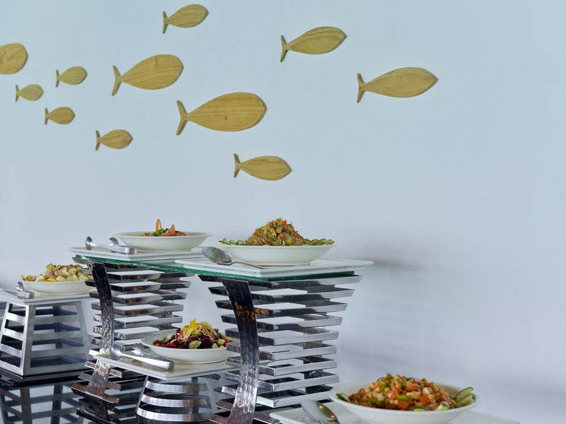 Buffet im Sommer Island Maldives mit verschiedenen Salaten auf Glastischen.
