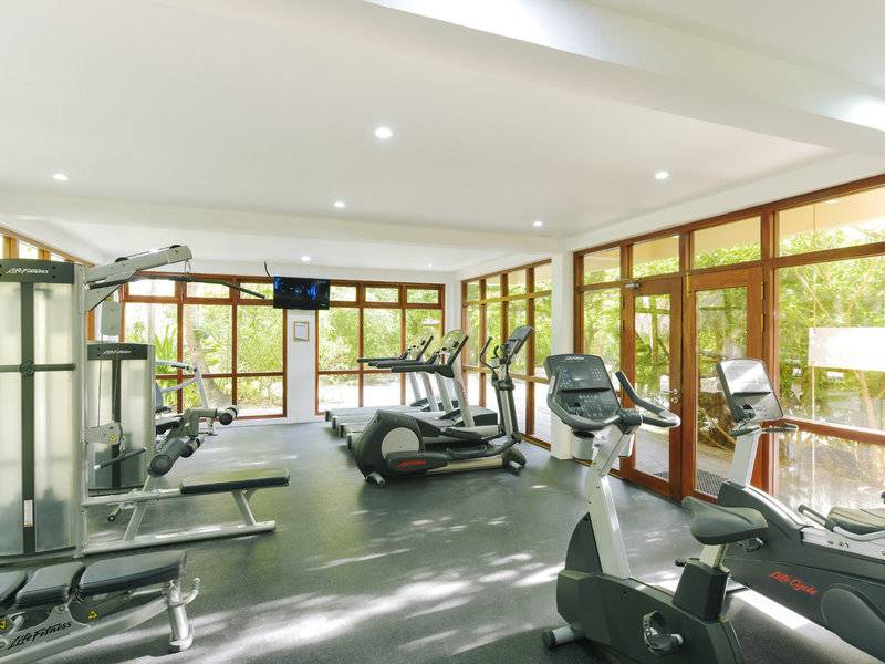 Fitnesscenter im Summer Island Maldives Hotel mit Geräten und Panoramafenstern.