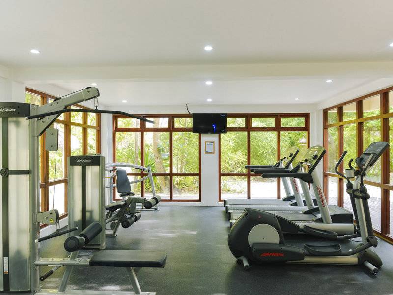 Fitnessstudio im Summer Island Maldives Hotel mit Fenstern und Trainingsgeräten.