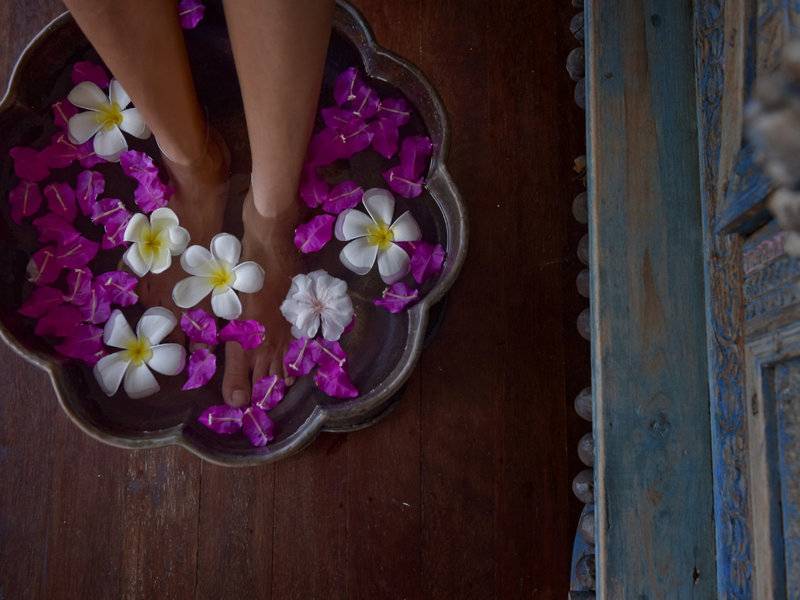 Füße in einem Blumenbad im Hotel Summer Island Maldives